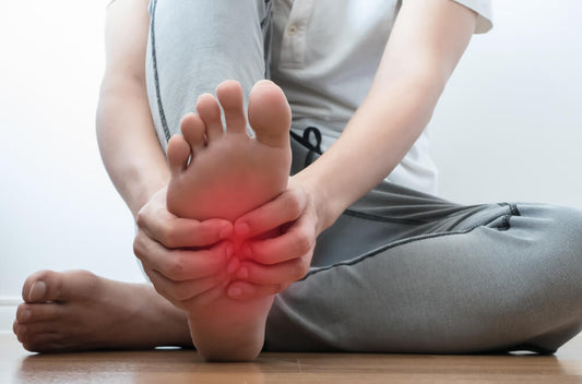 Woman massaging aching feet while sitting on the floor